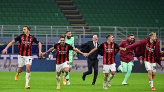 Para pemain AC Milan merayakan kemenangan setelah memenangkan pertandingan sepak bola Serie A Italia antara Inter Milan melawan AC Milan di Stadion Giuseppe Meazza, Milan, Italia, Minggu (18/10) dini hari WIB. [Miguel MEDINA / AFP]