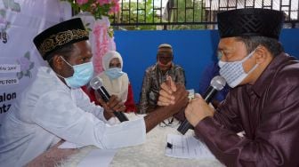 Petugas pencatat nikah Kantor Urusan Agama (KUA) sekaligus penghulu (kanan) melakukan proses Ijab Kabul terhadap pasangan pengantin di Kota Sorong, Papua Barat, Minggu (18/10/2020). [ANTARA FOTO/Olha Mulalinda]
