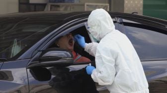 Warga menjalani tes usap PCR (Swab Test) tanpa turun dari kendaraan (drive-thru) di GSI Lab (Genomik Solidaritas Indonesia Laboratorium), Cilandak, Jakarta Selatan, Senin  (19/10/2020). [Suara.com/Angga Budhiyanto]