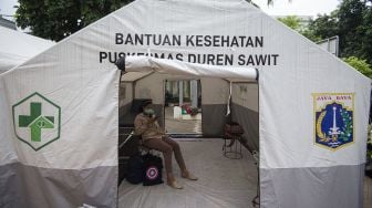 Pasien COVID-19 menunggu penjemputan dirinya ke Rumah Sakit Darurat Penanganan COVID-19 Wisma Atlet Kemayoran di Puskesmas Duren Sawit, Jakarta, Senin (19/10/2020). [ANTARA FOTO/Aditya Pradana Putra]