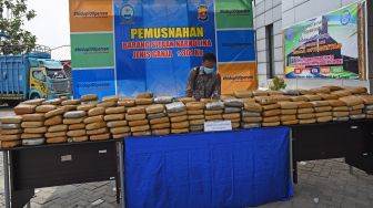 Petugas Badan Narkotika Nasional (BNN) Provinsi Banten menata ratusan paket ganja kering saat acara pemusnahan barang bukti di Serang, Banten, Rabu (21/10/2020). [ANTARA FOTO/Asep Fathulrahman]