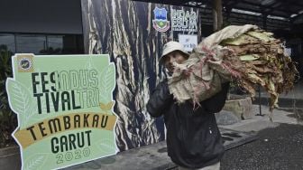 Petani membawa daun tembakau hasil panen di Festival Industri Tembakau Garut 2020 di kawasan Waterboom Banyoe Sinergi Mandala, Kabupaten Garut, Jawa Barat, Kamis (22/10/2020). [ANTARA FOTO/Candra Yanuarsyah]