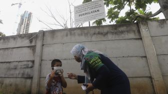 Satgas Padat Karya Penanganan COVID-19 Kelurahan Pejaten Barat memberikan sosialisasi protokol kesehatan kepada seorang anak di Kelurahan Pejaten Barat, Pasar Minggu, Jakarta, Kamis (22/10/2020). [Suara.com/Angga Budhiyanto]