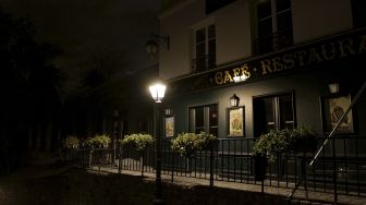 Restoran yang tutup di Montmartre di distrik 18 Paris, selama jam malam, pada (23/10/2020). [Valery HACHE / AFP]