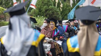 Sejumlah wisudawan bersama pendamping antre untuk mengikuti prosesi wisuda secara "Drive Thru" di Kampus Politeknik Negeri Sriwijaya (Polsri) Palembang, Sumatera Selatan, Sabtu (24/10/2020). [ANTARA FOTO/Nova Wahyudi]