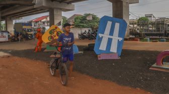 Seorang anak saat datang untuk mencoba jalur trek sepeda di Bike Park Pilar Jati, Kolong Tol Becakayu, Jakarta Timur, Minggu (25/10). [Suara.com/Alfian Winanto]