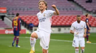 Gelandang Real Madrid Luka Modric (tengah) merayakan golnya setelah mencetak gol ketiga dalam pertandingan sepak bola Liga Spanyol antara Barcelona melawan Real Madrid di stadion Camp Nou, Barcelona, Spanyol, Sabtu (24/10).  [LLUIS GENE / AFP]
