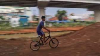 Seorang anak menjajal trek sepeda di Bike Park Pilar Jati, Kolong Tol Becakayu, Jakarta Timur, Minggu (25/10). [Suara.com/Alfian Winanto]