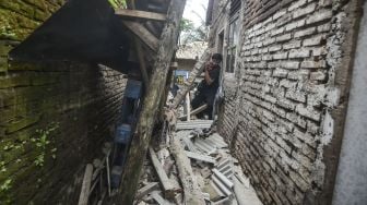 Warga menyaksikan rumah yang rusak akibat gempa bumi di Dusun Kertaharja, Kabupaten Pangandaran, Jawa Barat, Minggu (25/10/2020). [ANTARA FOTO/Adeng Bustomi]