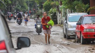 Warga mengungsikan barangnya ke area yang tidak terdampak banjir di Perumahan Villa Jatirasa, Kota Bekasi, Jawa Barat, Minggu (25/10). [Suara.com/Alfian Winanto]