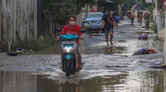 Sejumlah area jalan masih tergenang banjir di Perumahan Villa Jatirasa, Kota Bekasi, Jawa Barat, Minggu (25/10). [Suara.com/Alfian Winanto]