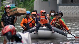 Petugas Polmas dan BPBD Kota Bogor mengevakuasi warga yang rumahnya terendam banjir di Perumahan Griya Cimanggu Indah, Kelurahan Kedung Badak, Tanah Sareal, Kota Bogor, Jawa Barat, Senin (26/10/2020). [ANTARA FOTO/Arif Firmansyah]