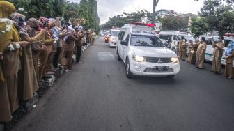 Sejumlah tenaga medis Dinas Kesehatan Kabupaten Bogor memberikan penghormatan terakhir kepada jenazah Kepala Puskesmas Banjarsari Dokter Usman, yang meninggal akibat COVID-19 di Jalan Raya Tegar Beriman, Kabupaten Bogor, Jawa Barat, Senin (26/10/2020). [ ANTARA FOTO/Yulius Satria Wijaya]