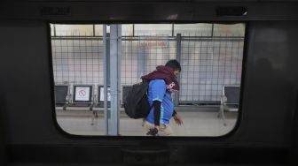 Seorang calon penumpang berjalan menuju rangkaian Kereta Api Matarmaja yang berhenti di Stasiun Pasar Senen, Jakarta, Selasa (27/10/2020). [Suara.com/Angga Budhiyanto]