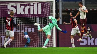 Penyerang Roma Edin Dzeko (kanan) mencetak gol ke gawang AC Milan selama pertandingan sepak bola Serie A Italia antara AC Milan melawan AS Roma di Stadion Meazza, Milan, Selasa (27/10) dini hari WIB. 
MIGUEL MEDINA / AFP