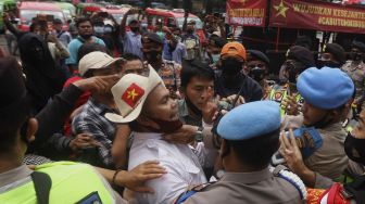 Massa dari Serikat Rakyat Miskin Indonesia (SRMI) bersitegang dengan aparat kepolisian saat melakukan aksi unjuk rasa di kawasan Patung Kuda Arjuna Wiwaha, Jakarta, Selasa (27/10/2020). [Suara.com/Angga Budhiyanto]