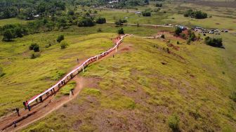 Foto aerial anggota karang taruna Puriala membentangkan bendera merah putih di kaki gunung Ahuawali, Kecamatan Puriala, Konawe, Sulawesi Tenggara, Rabu (28/10/2020).  [ANTARA FOTO/Jojon]