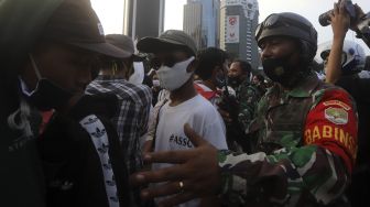 Personel TNI membubarkan massa yang melakukan aksi unjuk rasa di kawasan Patung Kuda Arjuna Wiwaha, Jakarta, Rabu (28/10/2020). [Suara.com/Angga Budhiyanto]