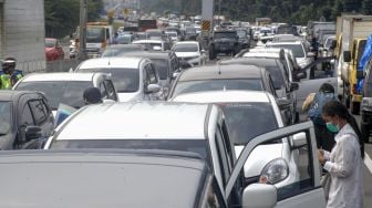 Sejumlah wisatawan keluar dari kendaraannya menunggu kemacetan reda akibat buka tutup jalan Puncak, Gadog, Kabupaten Bogor, Jawa Barat, Rabu (28/10/2020).  [ANTARA FOTO/Yulius Satria Wijaya]