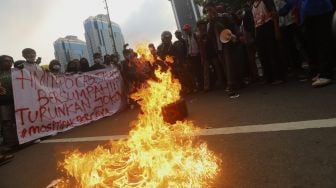 Massa aksi membakar ban saat melakukan aksi unjuk rasa di kawasan Patung Kuda Arjuna Wiwaha, Jakarta, Rabu (28/10/2020). [Suara.com/Angga Budhiyanto]