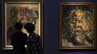 Pengunjung mengamati lukisan maestro seni lukis Affandi di pameran imersif Affandi: Alam, Ruang, Manusia di Galeri Nasional Indonesia, Jakarta, Jumat (30/10/2020). [Suara.com/Angga Budhiyanto]