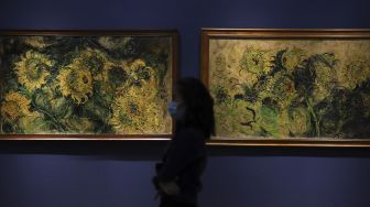 Penjaga berada di depan lukisan maestro seni lukis Affandi di pameran imersif Affandi: Alam, Ruang, Manusia di Galeri Nasional Indonesia, Jakarta, Jumat (30/10/2020). [Suara.com/Angga Budhiyanto]