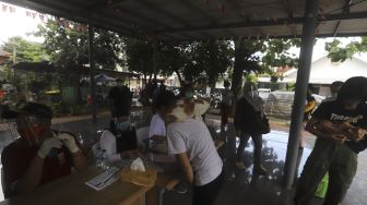 Sejumlah warga mengantre untuk memeriksa kesehatan hewan peliharaannya dan vaksinasi rabies secara gratis di RPTRA Taman Mandala, Tebet, Jakarta, Sabtu (31/10/2020). [Suara.com/Angga Budhiyanto]