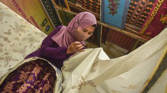 Seorang perempuan belajar mencanting batik Melayu Riau di Galeri Semat Tembaga, di Kota Pekanbaru, Riau, Sabtu (31/10/2020). [ANTARA FOTO/FB Anggoro]