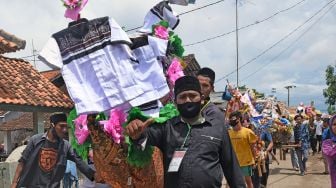 Warga menggotong aneka barang sedekah saat Perayaan Maulid Nabi Muhammad SAW di Kampung Tegalparang, Soyog, Serang, Banten, Minggu (1/11/2020). [ANTARA FOTO/Asep Fathulrahman]