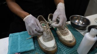 Kru melepas tali sepatu untuk dibersihkan di Cleaning Shoes Kicks Kemon, Haji Nawi, Jakarta Selatan, Minggu (1/11). [Suara.com/Alfian Winanto]