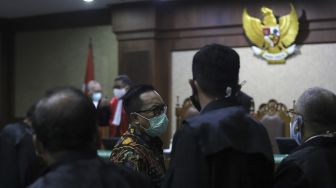 Terdakwa kasus suap penghapusan red notice Djoko Tjandra, Brigjen Prasetijo Utomo berbincang dengan tim penasehat hukum saat menjalani sidang dakwaan di Pengadilan Tipikor, Jakarta, Senin (2/11/2020). [Suara.com/Angga Budhiyanto]