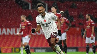 Striker Arsenal Pierre-Emerick Aubameyang usai mencetak gol pembuka dari titik penalti selama pertandingan sepak bola Liga Inggris antara Manchester United melawan Arsenal di Old Trafford, Manchester, Inggris, Minggu (1/11). [PHIL NOBLE / POOL / AFP]