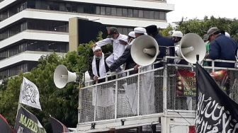 Sambil Digendong, Anak Ini Disuruh Injak Poster Berwajah Presiden Prancis