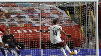 Striker Arsenal Pierre-Emerick Aubameyang mencetak gol pembuka dari titik penalti selama pertandingan sepak bola Liga Inggris antara Manchester United melawan Arsenal di Old Trafford, Manchester, Inggris, Minggu (1/11). [PHIL NOBLE / POOL / AFP]