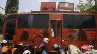 Sejumlah kendaraan bermotor terparkir di dekat tumpukan bangkai kendaraan dinas yang sudah tidak layak pakai di Kantor Dinas Lingkungan Hidup DKI Jakarta, Kramat Jati, Jakarta, Rabu (4/11/2020). [Suara.com/Angga Budhiyanto]