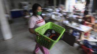 Pekerja membawa keranjang berisi masker kain di industri konveksi Rumah Kita Production di kawasan Tanjung Barat, Jakarta, Kamis (5/11/2020). [Suara.com/Angga Budhiyanto]