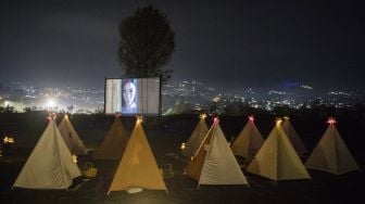 Pengunjung berada di dalam tenda saat menyaksikan film di bioskop outdoor Tenda di Bawah Bintang, Parongpong, Kabupaten Bandung Barat, Jawa Barat, Rabu (4/11/2020). [ANTARA FOTO/M Agung Rajasa]