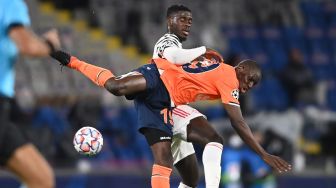 Penyerang Istanbul Basaksehir Demba Ba (kanan) memperebutkan bola dengan bek Manchester United Axel Tuanzebe selama pertandingan sepak bola Liga Champions UEFA grup H, antara Istanbul Basaksehir FK melawan Manchester United, di Stadion Basaksehir Fatih Terim, Kamis (5/11/2020) dini hari WIB. OZAN ​​KOSE / AFP
