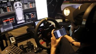 Seorang pembalap mengatur suspensi mobil balapnya saat melakukan sesi latihan menggunakan simulator balap di P1 Academy Motorsport Indonesia (ADMI), Kebayoran Baru, Jakarta, Jumat (6/11/2020). [Suara.com/Angga Budhiyanto]