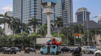 Suasana arus lalu lintas disekitat Tugu Jam Thamrin  di Jl. MH. Thamrin, Jakarta Pusat, Minggu (8/11). [Suara.com/Alfian Winanto]