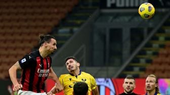 Penyerang AC Milan Zlatan Ibrahimovic (kiri) menyundul bola untuk mencetak gol selama pertandingan sepak bola Serie A Italia antara AC Milan melawan Verona di Stadion San Siro, Milan, Italia, Senin (9/11) dini hari WIB.  [Miguel MEDINA / AFP]