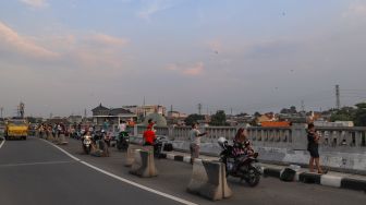 Warga memenuhi sisi samping Fly Over Kalibata untuk bermain layangan di Jakarta Selatan, Senin (9/11). [Suara.com/Alfian Winanto]