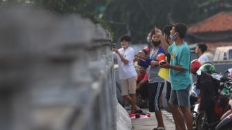 Warga menerbangkan layangannya di samping Fly Over Kalibata, Jakarta Selatan, Senin (9/11). [Suara.com/Alfian Winanto]