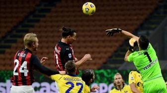 Penyerang AC Milan Zlatan Ibrahimovic (kiri) menyundul bola untuk mencetak gol selama pertandingan sepak bola Serie A Italia antara AC Milan melawan Verona di Stadion San Siro, Milan, Italia, Senin (9/11) dini hari WIB.  [Miguel MEDINA / AFP]