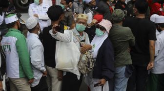 Massa berswafoto saat menyambut kedatangan Imam Besar Front Pembela Islam (FPI) Habib Rizieq Shihab di markas Front Pembela Islam, Petamburan, Jakarta, Selasa (10/11/2020). [Suara.com/Angga Budhiyanto]