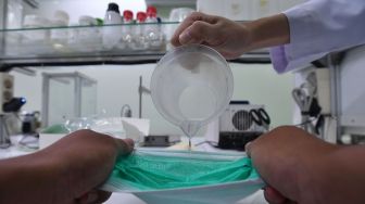 Petugas lab menguji ketahanan masker yang diproduksi di PT The Univenus Cikupa, Cikupa, Tangerang, Banten, Rabu (11/11/2020).  [ANTARA FOTO/Sigid Kurniawan]