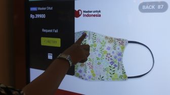 Pengunjung memilih masker yang dijual pada "vending machine" di Senayan City Mall, Jakarta, Rabu (11/11/2020). [Suara.com/Angga Budhiyanto]