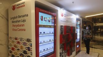 Pengunjung memilih masker yang dijual pada "vending machine" di Senayan City Mall, Jakarta, Rabu (11/11/2020). [Suara.com/Angga Budhiyanto]