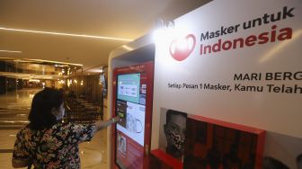 Pengunjung memilih masker yang dijual pada "vending machine" di Senayan City Mall, Jakarta, Rabu (11/11/2020). [Suara.com/Angga Budhiyanto]