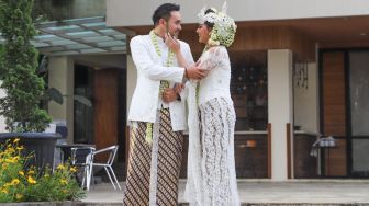 Pedangdut Jenita Janet dan suaminya, Danu Sofwan berpose didepan kamera usai melangsungkan pernikahan di Green Forest Resort, Bandung, Jawa Barat, Rabu (11/11). [Suara.com/Alfian Winanto]